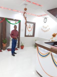 a man standing in a room with a wall with decorations at Benda Rejuvenate Hotel in Jodhpur