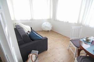 Kapitaenshaus-Lassen-Zimmer-Kapitaen-Blaubaer في فيسترلاند: غرفة معيشة بها أريكة وطاولة +6 صور