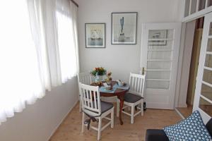 Kapitaenshaus-Lassen-Zimmer-Kapitaen-Blaubaer في فيسترلاند: غرفة طعام مع طاولة وكرسيين وطاولة وكرسي