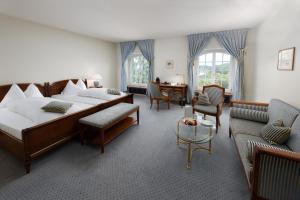 een hotelkamer met 2 bedden en stoelen en een tafel bij Hotel Stadthaus in Burgdorf