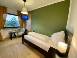 a bedroom with a bed and a table and a window at Landgasthaus Löwen mit Gästehaus in Holzhausen