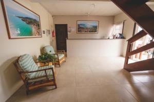 un pasillo con 2 sillas y una sala de espera en Pousada Village Garopaba, en Garopaba