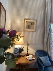 een woonkamer met een tafel en een blauwe stoel bij Villa du Châtelet in Choisy-au-Bac