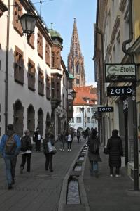 a group of people walking down a city street at FeWo - Mitten In Freiburg in Freiburg im Breisgau