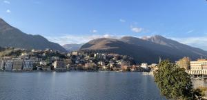 une ville sur l'eau avec des montagnes en arrière-plan dans l'établissement CASA DEL LAGO, à Omegna