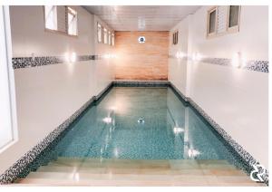 a swimming pool in a gymnasium with an indoor swimming pool at De Rose Centro Hotel in Torres