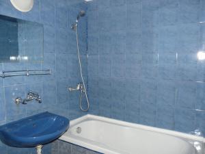 ein blau gefliestes Bad mit einer Badewanne und einem Waschbecken in der Unterkunft Family Hotel Balchik in Baltschik