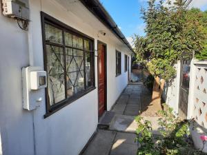una casa con una puerta roja y una ventana en casa completa Balmaceda 77 en Concepción