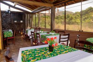 a restaurant with tables and chairs with flowers on them at Dunas de Itaipu in Niterói