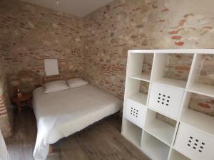 a small room with a bed and white shelves at Le pigeonnier de La Mouline in Viterbe
