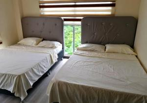two beds sitting next to each other in a room at Casa Quinta Campestre con Piscina Privada Anapoima in Anapoima +14 photos