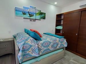 1 dormitorio con 1 cama con almohadas azules en Riviera Maya Luxury Oceanfront Condo, en Akumal