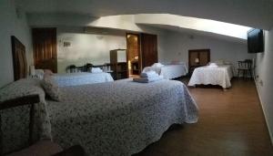 um quarto de hotel com duas camas com lençóis brancos em posada trastamara em Piedralaves