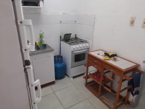 una pequeña cocina con fogones y mesa. en Lo de IRMA, en Piriápolis