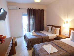 a hotel room with two beds and a television at Anna house 1 in Sarti