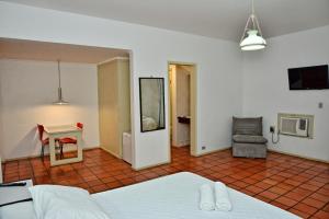 a bedroom with a bed and a table and a chair at De Rose Centro Hotel in Torres +27 photos
