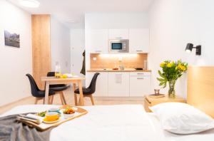 a room with a bed and a kitchen with a table at Zaži Apartmán Vila Zuberec in Zuberec