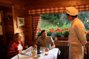 a group of people sitting at a table in a restaurant at Albergo Villa Anna Maria in Champoluc