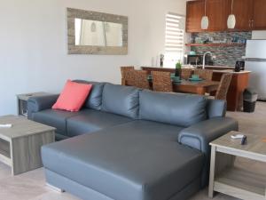 a living room with a blue couch with a red pillow at Riviera Maya Luxury Oceanfront Condo in Akumal