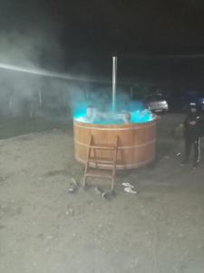 a hot tub in the sand with a man standing next to it at LIVADA AMELY in Galeş