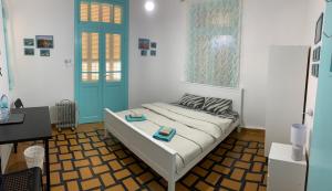a bedroom with a bed with a blue door and a desk at Apartments COMFY in Haifa