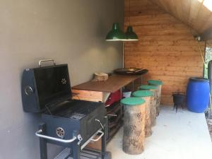 a kitchen with a stove and a table with stools at WyspaDrzewoDomek in Kamionna