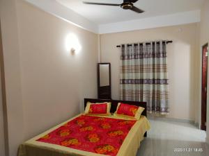 - une chambre avec un lit doté d'oreillers rouges et une fenêtre dans l'établissement Victory's Residence, Mannar, à Mannar