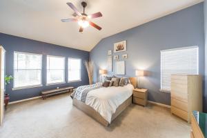 a bedroom with blue walls and a bed with a ceiling fan at Cozy home near Houston Medical Center, NRG Stadium and Galleria in Manvel