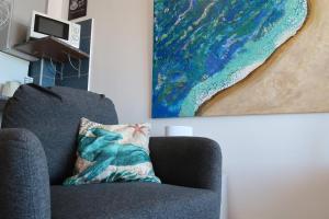 a living room with a couch and a painting at Ocean View Deluxe Studio in Playa Paraiso