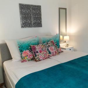 a bedroom with a bed with pillows and a mirror at Paradise Apartman in Miskolc