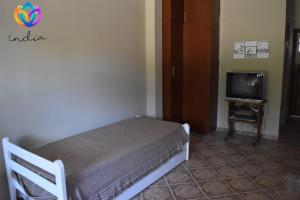 Dormitorio pequeño con cama y TV en India en Chascomús