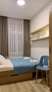 sypialnia z łóżkiem, krzesłem i oknem w obiekcie Sopot Special Apartments w mieście Sopot