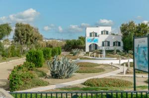 un edificio con un cartel frente a un jardín en Dolphin Studios, en Agia Anna de Naxos