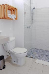 La salle de bains blanche est pourvue d'une douche et de toilettes. dans l'établissement Lucky Duck PJ, à Cancún