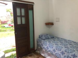 a bedroom with a bed next to a door at Paraiso dos Reis in Itaqui