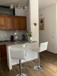 una cucina con due sedie bianche e un bancone di Living Downtown Codice IUN Q4645 a Cagliari