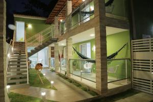 Cette maison moderne est dotée d'un escalier et de murs verts. dans l'établissement Flats Angatu Porto de Galinhas PE, à Porto de Galinhas