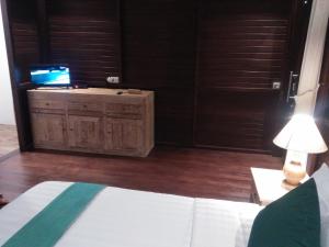 1 dormitorio con 1 cama y TV en un armario en Villa Wedang, en Tegalalang