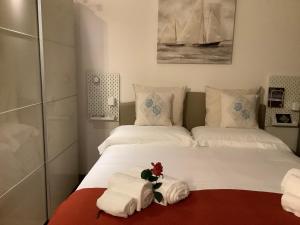 1 dormitorio con 2 camas, toallas y un juguete relleno en Living Downtown Codice IUN Q4645 en Cagliari