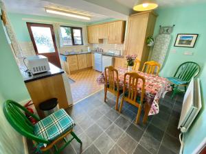 een keuken en eetkamer met een tafel en stoelen bij Kilbroney Rest in Rostrevor