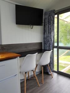 a kitchen with a table and two white chairs at Millers Flat Holiday Park in Millers Flat