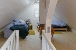 a attic bedroom with two beds and a staircase at Ferienhaus Däschinger in Mastershausen