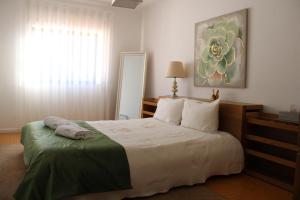 Un dormitorio con una cama grande y una ventana en Casa Sandra - Apartamento Carlota, en Lousã