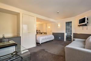 um quarto de hotel com uma cama e um sofá em Pure Chalet Thredbo em Thredbo