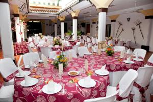 un comedor con mesas y sillas blancas en Hostal El Cortijo, en Algodonales