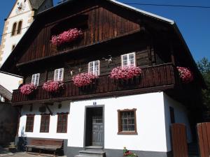 ein Haus mit rosa Blumen auf dem Balkon in der Unterkunft Landhaus Alpentraum in Kaning