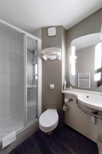 a bathroom with a toilet and a sink and a shower at ibis Dole Sud Choisey in Dole +73 photos