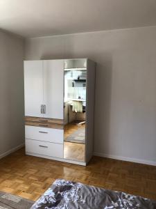 a bedroom with a mirror and a white cabinet at Gästehaus Alm-Blick in Murrhardt
