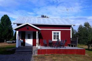 un fienile rosso con sedie di fronte di Guesthouse a Öjebyn