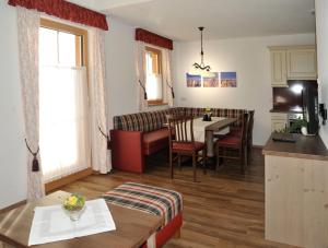 a kitchen and a living room with a table and chairs at Landhaus Katharina in Ramsau am Dachstein
